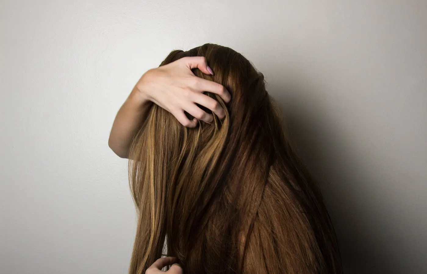 women running fingers through hair - how to get healthy shiny hair