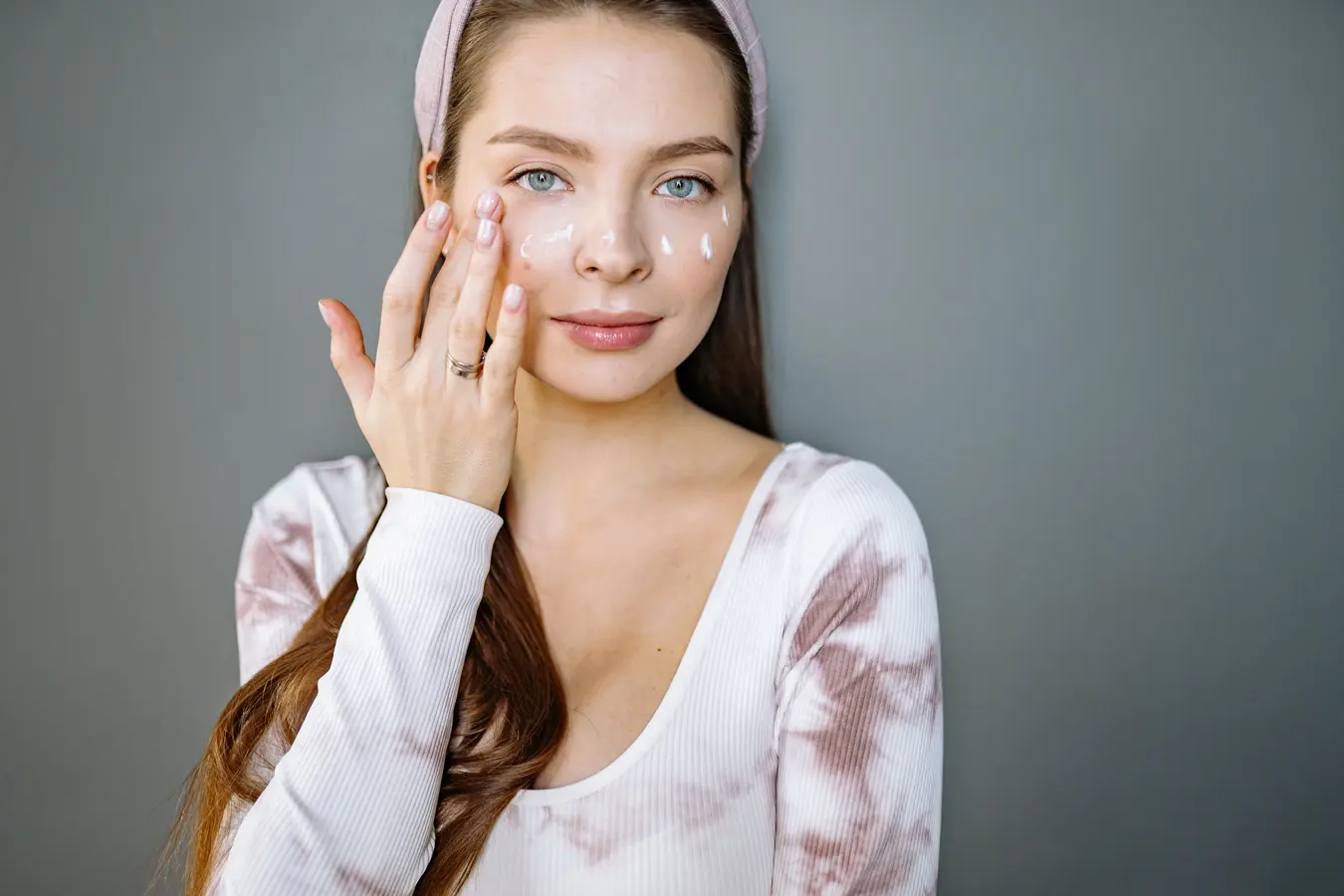 girl putting on face cream - skincare routine for dry winter skin