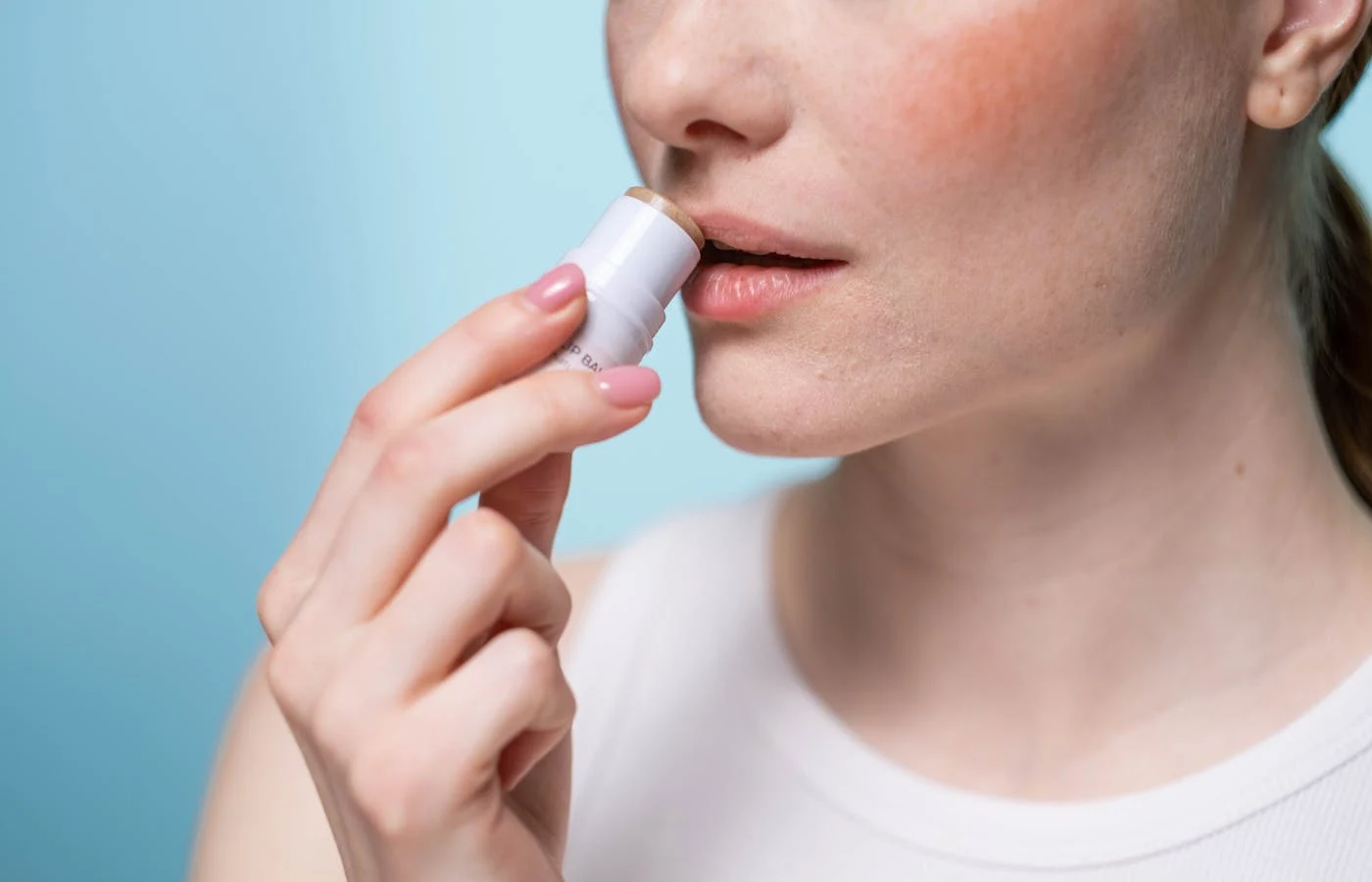 Woman using a lip balm.- Best Lip Balms for Dry Lips