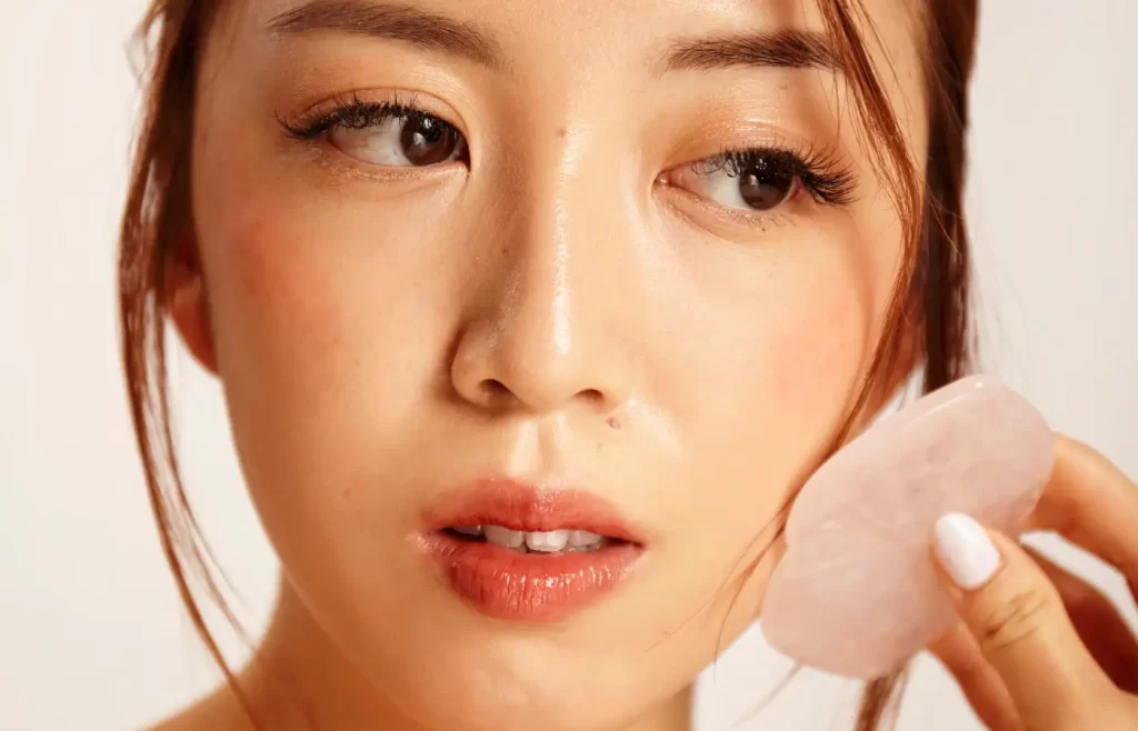 Close up of woman's skin with gua sha. - Korean Skincare Tips