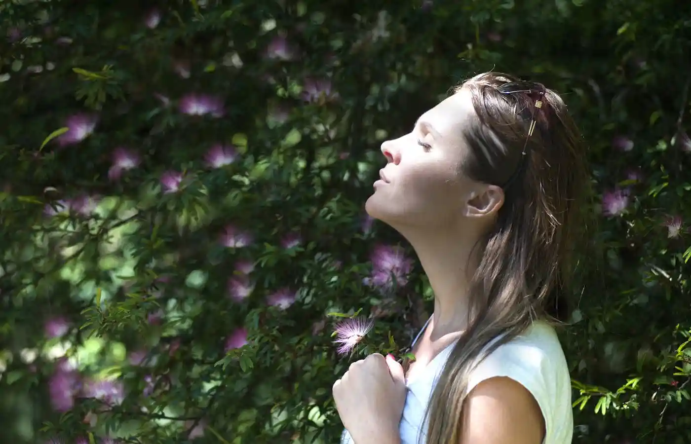 Woman closing her eyes against sun light - Top 10 Skin Care Tips For Summer