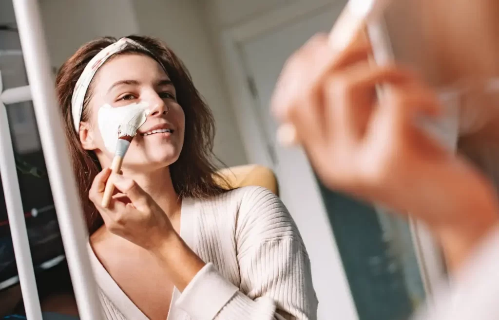 Woman applying face mask to skin - types of face masks for skin