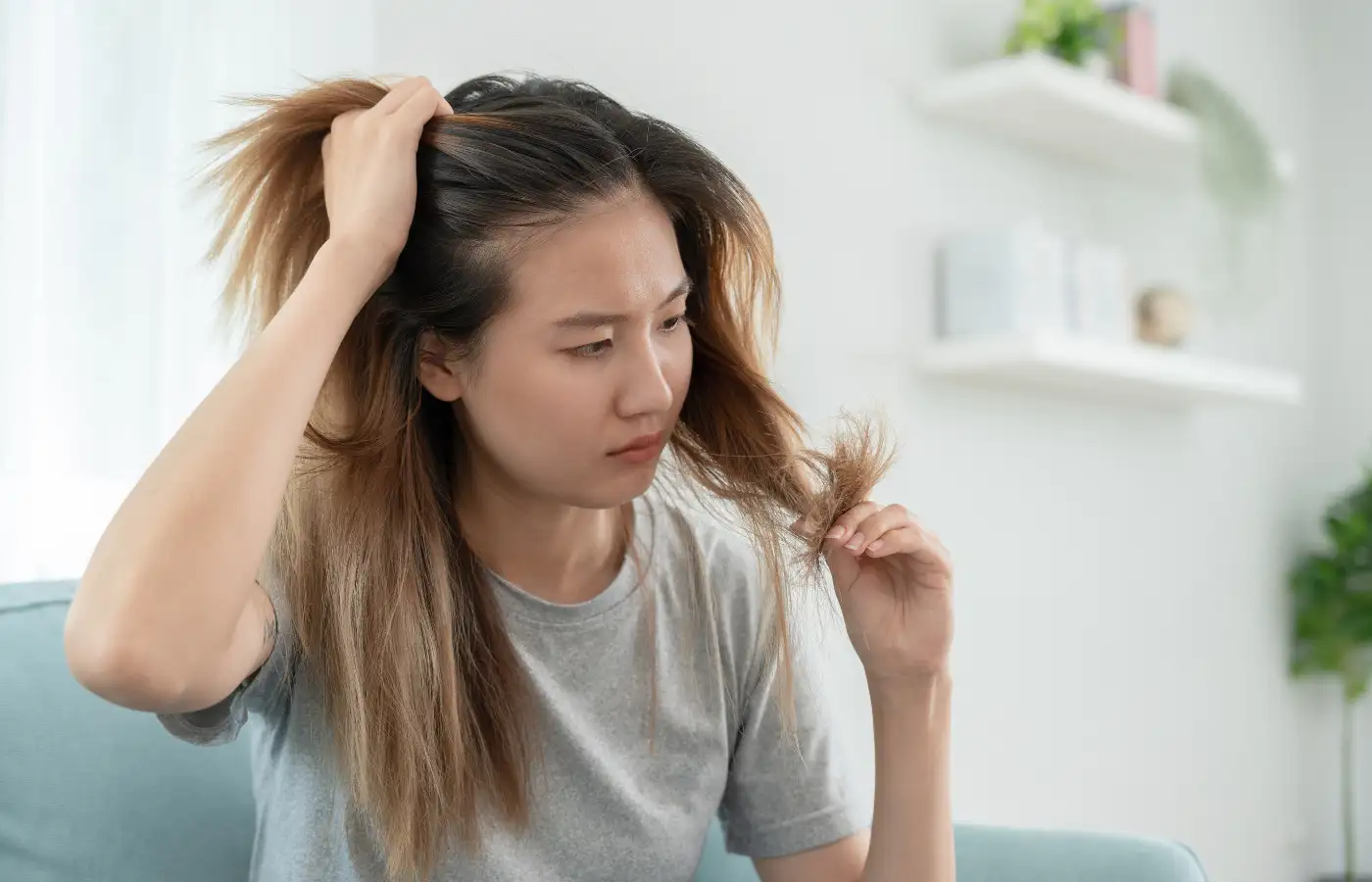 Woman looking at her dry hair - hair care routine for low porosity hair